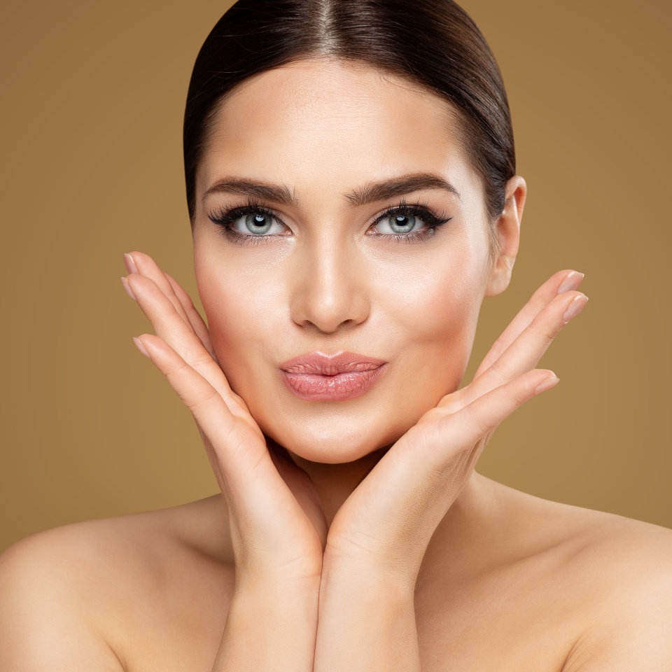 Beauty Model showing Cheekbones and Full Lips. Beautiful Woman Face Skin Care. Women Dermal Filler and Permanent Make up Cosmetology. Lip Augmentation Facial Lifting Spa Massage